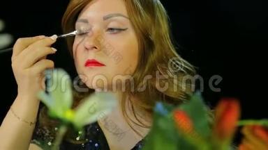 化妆室里的红发女演员用银色的火花做眼妆，准备上台